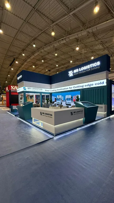 The MS Logistics reception counter and screen kiosks along the long side of the stand.