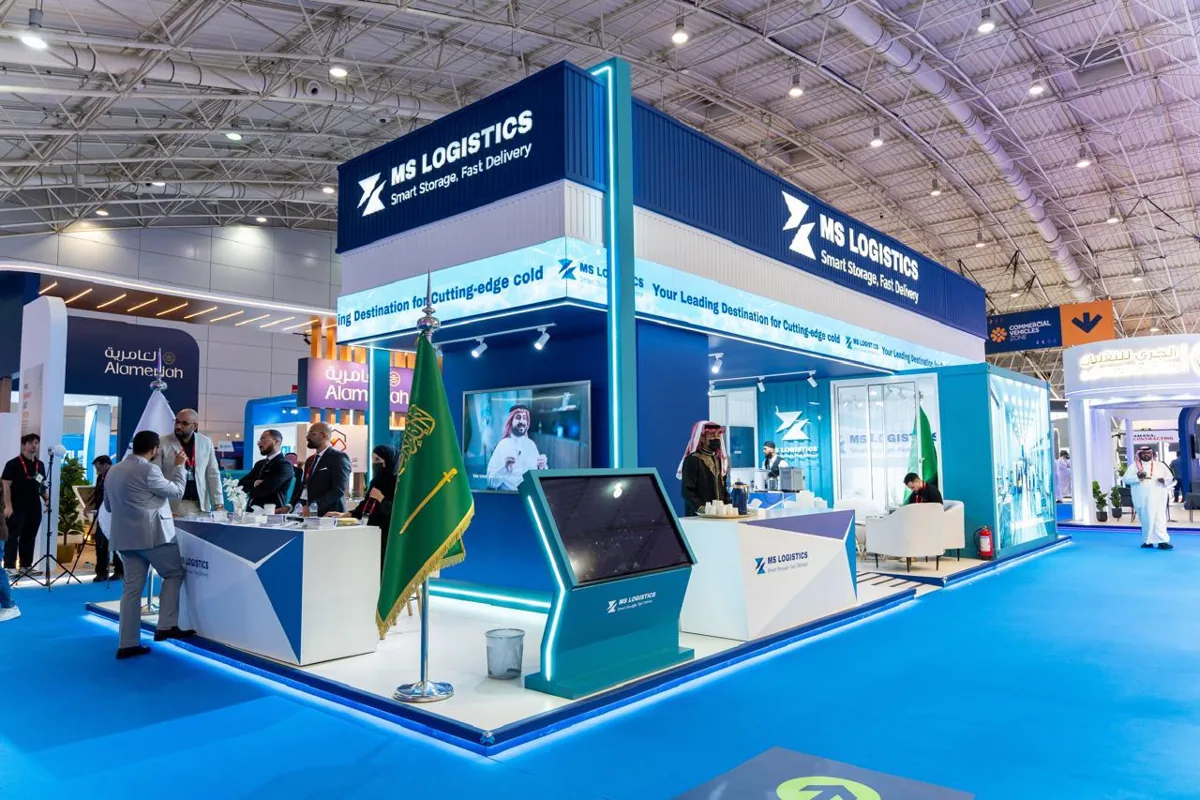 Visitors at the MS Logistics reception counters, with the Saudi flag at the corner of the stand.